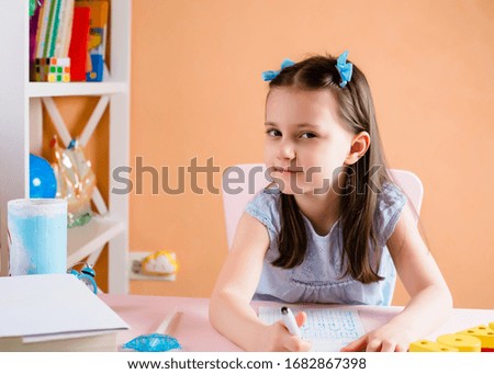 A preschooler or primary school girl does homework. Learning English. Back to school. Home study