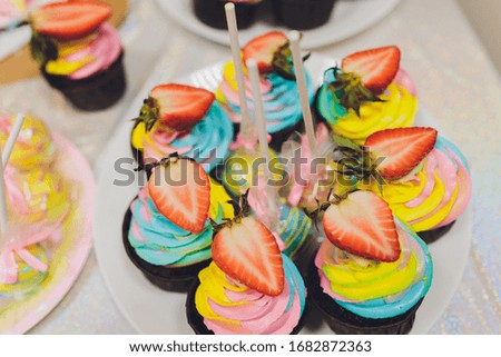 Colorful birthday cupcakes on white wooden table, flat lay.
