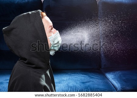 Influenza, cold, coronavirus. Infection through an airborne droplet. Girl in a hood and in a medical mask in front of a cloud of drops in the air Royalty-Free Stock Photo #1682885404