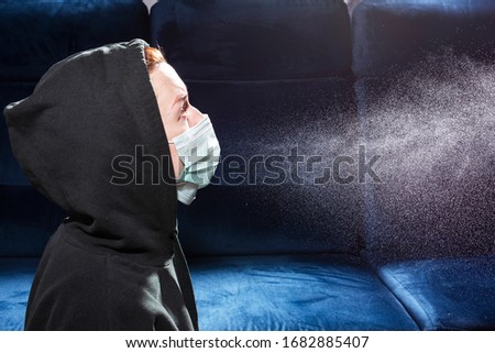 Influenza, cold, coronavirus. Infection through an airborne droplet. Girl in a hood and in a medical mask in front of a cloud of drops in the air Royalty-Free Stock Photo #1682885407