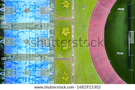 Aerial view of empty sport fields on the university campus. Bright and vigorous colours. Geometric patterns.