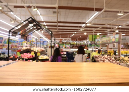 Empty wooden table on a shelf in a supermarket ,blurred image of shopping mall,bokeh background.