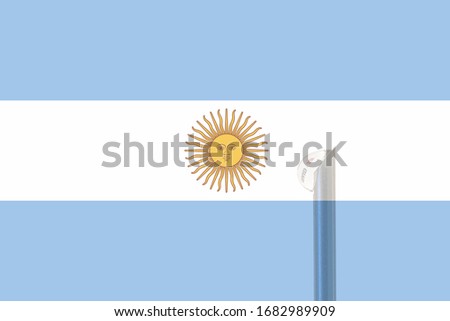 Argentine flag and vaccine needle from which a drop of liquid comes out. In the drop. there is a text that says covid-19. Concept of prevention and health care.