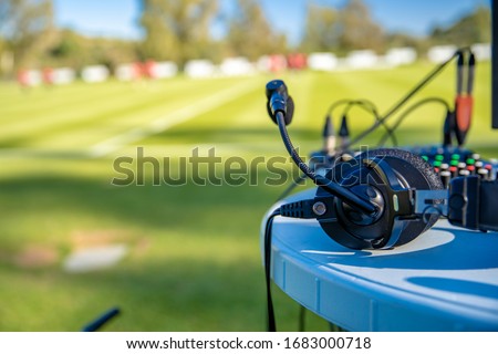 commentator headsets on the table next to the football field. stream for television and radio Royalty-Free Stock Photo #1683000718