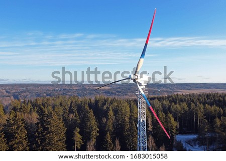 Wind turbines against a blue sky and woods, with blades in colors of the Russian flag, photo by quadcopter (copter, drone)