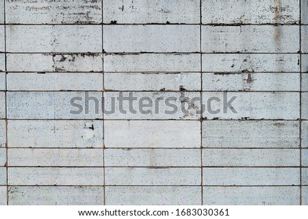 Texture of the wall of an old building with a white and blue mosaic pixel structure
