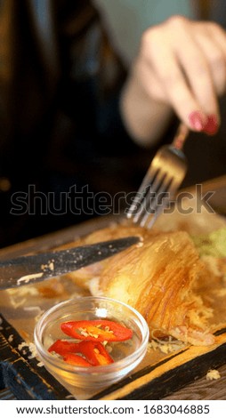 vertical shot. woman eating French fries in restaurant.
