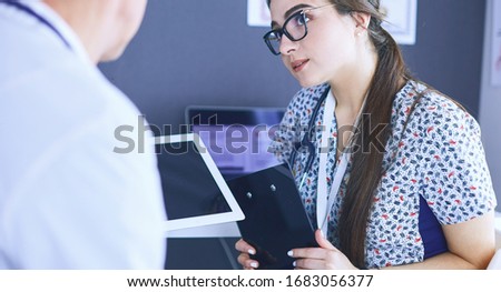 Two doctors speaking in a bright office