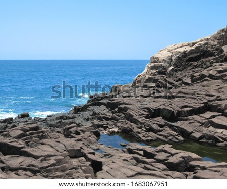 photos of Praia do Rosa taken in Santa Catarina, Brazil, with rock and sea