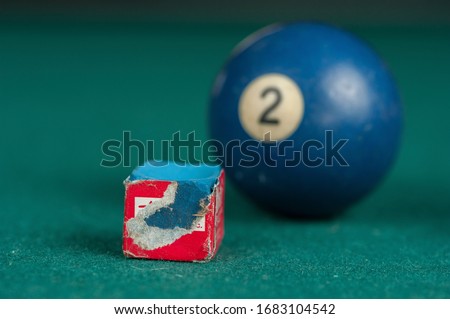 Billiards balls and cue on billiards table. Billiard sport concept. Chalk block on biliard table.