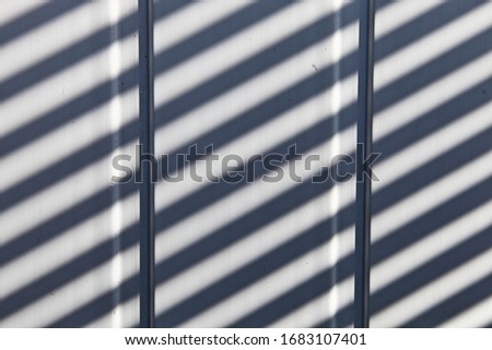 Vertical white plastic planks with diagonal sun rays blsck shadows, texture for background