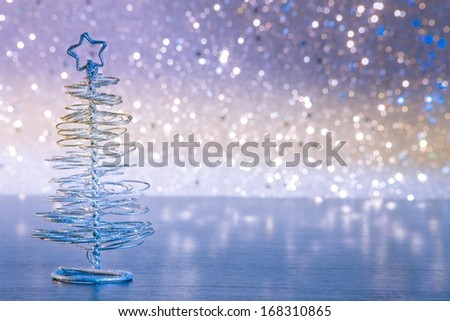 close-up of metallic modern christmas tree on wood table on colorful tint light bokeh background with space for text