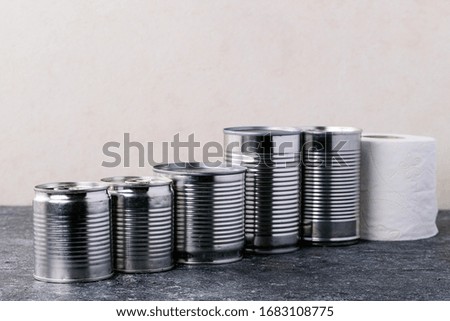 Canned food in metal cans over white texture background. Copy space. Food supply concept