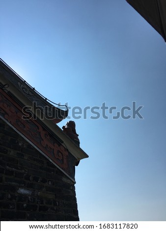 Qilin (Kirin), the lion guardian on the roof of old house in Dapeng Ancient City with clear blue sky background, Longgang, Shenzhen, Guangdong, China, Asia. The picture was taken in May 2018.
