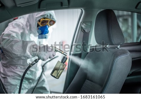 Clean surfaces in car with a disinfectant spray. Help kill coronavirus in  car after going out. Royalty-Free Stock Photo #1683161065