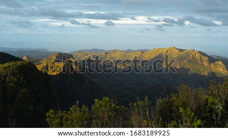 Sunset over coromandel peninsula mountain range light rays, warm
