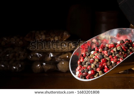 Mixed pepper peas in a metal scoop on a dark background