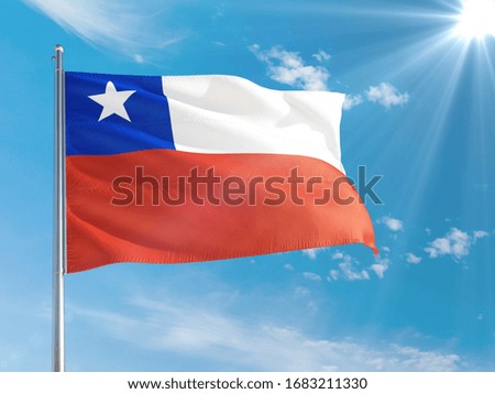 Chile national flag waving in the wind against deep blue sky. High quality fabric. International relations concept.