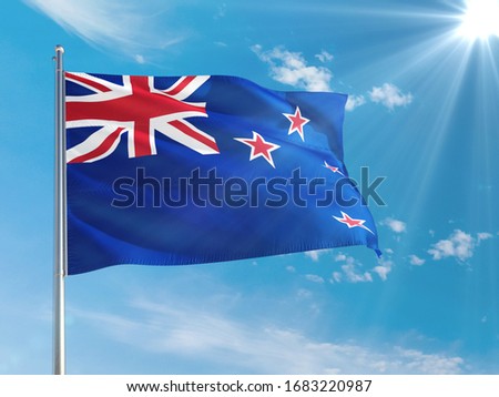 New Zealand national flag waving in the wind against deep blue sky. High quality fabric. International relations concept.