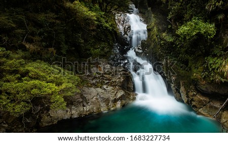 Milford Sound / New Zealand - 14 September 2016: Beautiful waterfall on the road between Te Anau and Milford Sound