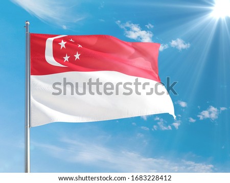 Singapore national flag waving in the wind against deep blue sky. High quality fabric. International relations concept.
