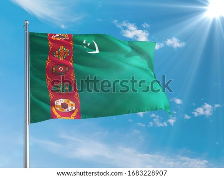Turkmenistan national flag waving in the wind against deep blue sky. High quality fabric. International relations concept.