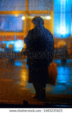 Shape of an old woman through the rain