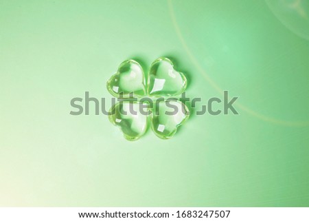 Imitation of a Lucky four leaf clover with four glass hearts on a green background for St. Patricks Day. Space for text, digital texture design concept
