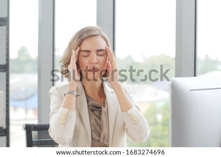 Businesswoman so tried headache and suffering stress working at office computer table. Office Syndrome Symptoms Concept.