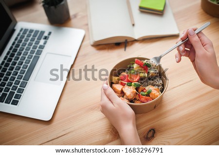 A woman has lunch and works at home. Close-up. Top view. Space for text in the smartphone Royalty-Free Stock Photo #1683296791