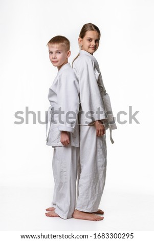Boy and girl in sports kimono stand with their backs to each other