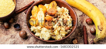 Sweet millet porridge with bananas and nuts in ceramic bowl.