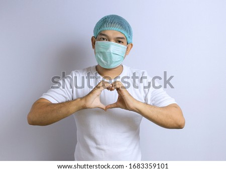 Photo image portrait of young Asian man wearing protective mask and hair cap against the corona virus covid 19. Asian man dressed as doctor or researcher isolated over white