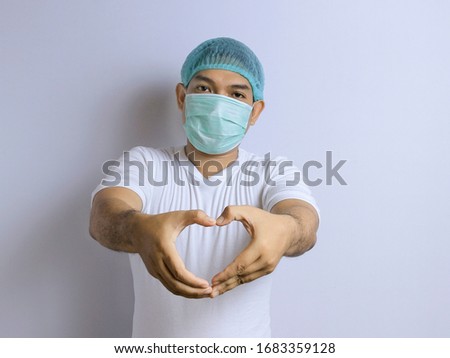 Photo image portrait of young Asian man wearing protective mask and hair cap against the corona virus covid 19. Asian man dressed as doctor or researcher isolated over white