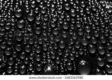 Minimalistic abstract black trendy background. Small drops of water on a dark surface.