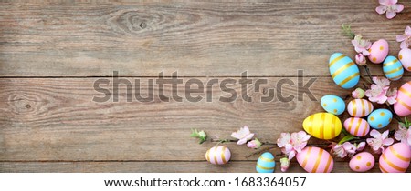Easter background with eggs and beautiful spring flowers on wooden table.