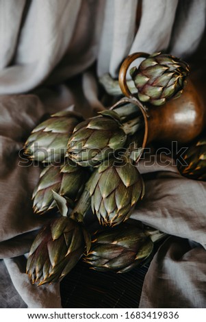 artichokes on grey background. fresh organic raw artichoke flowers in vase