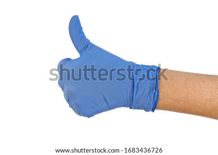 Hand of surgeon in blue medical glove showing thumbs up sign
