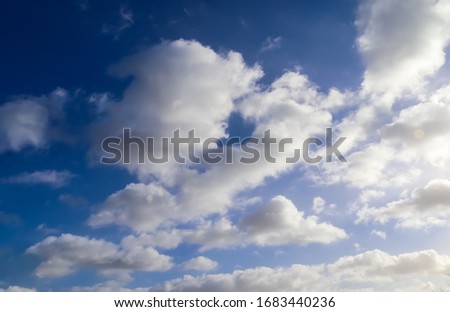 Beautiful white and fluffy clouds in a deep blue sunny sky