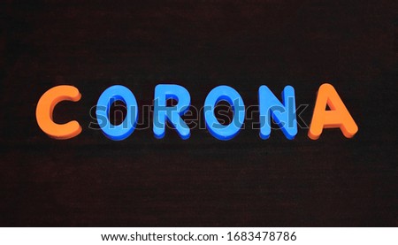 Corona word written with different colored letter blocks arranged on a dark background