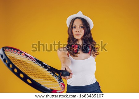 A nice brunette listens to the music, with the hat on her head and a rocket in her hand. Place for text placement.