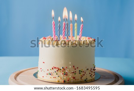 Birthday cake  with colorful candles on blue colour background with copy space banner cover concept background.