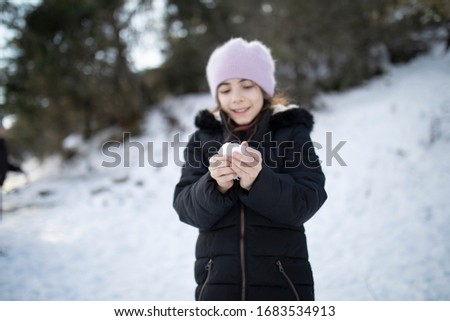 Happy little girl on the snowy forest