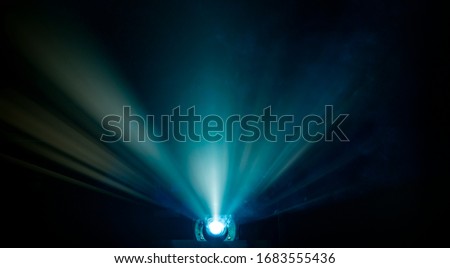 Rays of light coming from a digital projector in a theatre room  