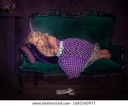 
Cute girl in a purple dress with white polka dots in a purple room
