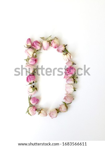 The letter D is made up of small pink roses on a white background