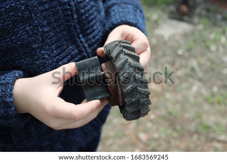 A high angle closeup shot of a human hand holding a small toy wheel