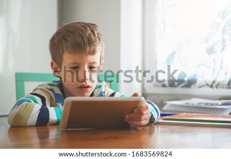 Young Boy Looking at Digital Tablet	
