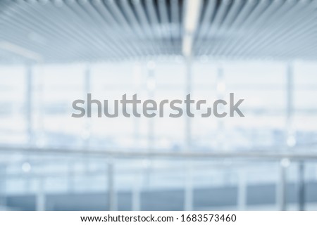 BLURRED SPACIOUS OFFICE BACKGROUND, MODERN BLUE BUSINESS HALL, LIGHT COMMERCIAL OPEN SPACE WITH BIG WHITE GLASSY WINDOWS, DEFOCUSED HALLWAY