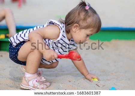 little girl is playing on the playground happy child is relaxing with mom rejoices and laughs